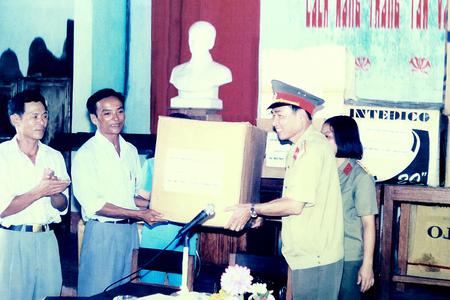 Đại tá Nguyễn Văn Châu, Chủ nhiệm Chính trị Binh chủng tặng quà của cán bộ, chiến sĩ BộTư lệnh Thông Tin Liên Lạc giúp đỡ đồng bào xã Ngư Thủy, Lệ Thủy, Quảng Bình, năm 1999