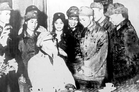 Bác Hồ tặng hoa chiến sĩ thông tin Lâm Thị Mỹ Bình tại Triển lãm tranh của Bộ đội Thông tin liên lạc, năm 1968